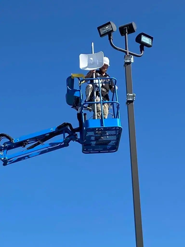 Succeed.Net technician installing network equipment from a manlift